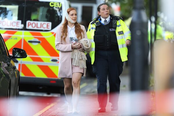 An injured woman is led away after an incident at Parsons Green underground station in London, Britain, September 15, 2017 - Sputnik International
