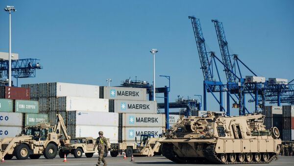 Soldiers walk near U.S. military equipment which arrived as part of NATO mission at port in Gdansk, Poland - Sputnik International