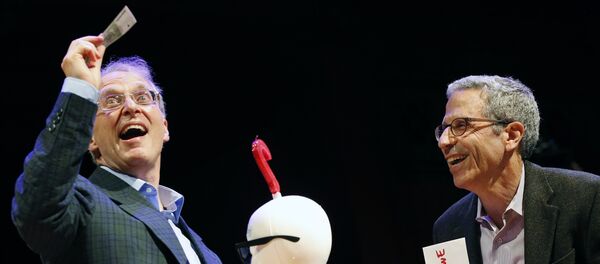 James Heathcote, left, reacts after receiving the Ig Nobel Anatomy Prize from Nobel laureate Eric Maskin (economics, 2007) during ceremonies at Harvard University in Cambridge, Mass - Sputnik International