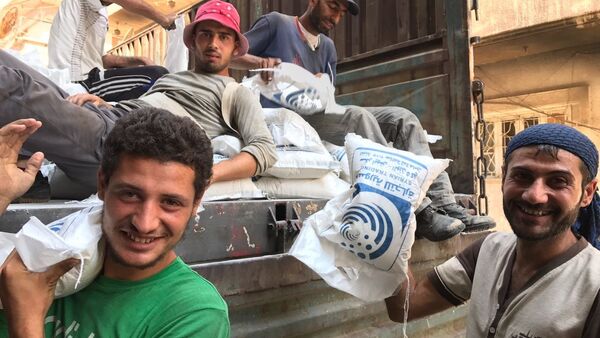 Men unload a van with sugar in Deir ez-Zor. - Sputnik International