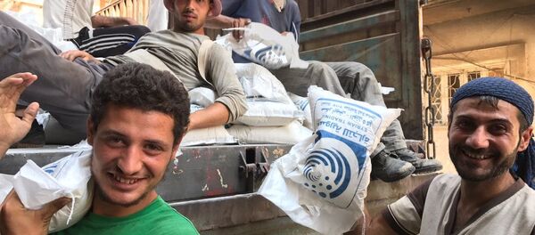 Men unload a van with sugar in Deir ez-Zor. - Sputnik International