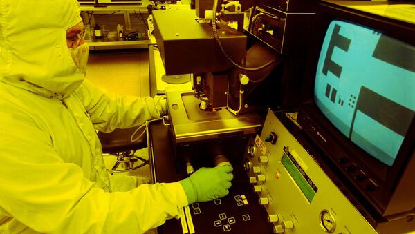 A microchip is projected on a screen by a microscope in a photo lithography room where film emulsion is applied to a microchip wafer - Sputnik International