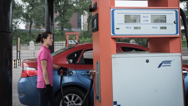 In this photo taken on July 21, 2017, a petrol pump attendant fills up a taxi with gasoline at a fuel station in Pyongyang - Sputnik International