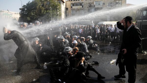 Israeli ultra-Orthodox Jewish men are sprayed with water during clashes with police at a protest against the detention of a member of their community who refuses to serve in the Israeli army, in Jerusalem September 17, 2017 - Sputnik International