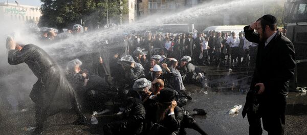 Israeli ultra-Orthodox Jewish men are sprayed with water during clashes with police at a protest against the detention of a member of their community who refuses to serve in the Israeli army, in Jerusalem September 17, 2017 - Sputnik International