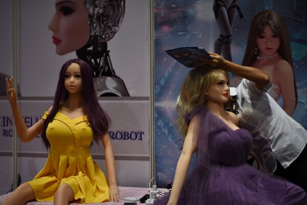 An exhibitor (R) adjusts an adult sex toy doll at her stall during the Asia Adult Expo in Hong Kong - Sputnik International