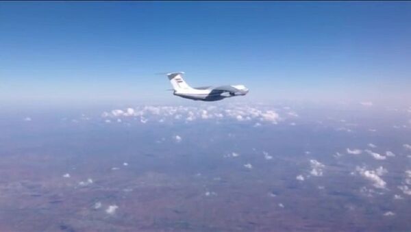 Syrian Air Force aircraft before dropping humanitarian cargo on Russian parachute platforms in the area of Deir ez-Zor, Syria. (A snap shot from the video published by the Russian Defense Ministry at its official YouTube channel. - Sputnik International