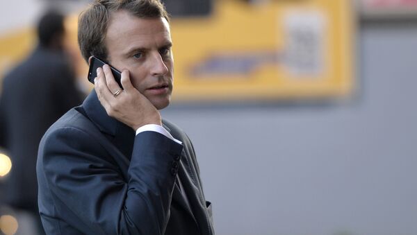 French Economy and Industry minister Emmanuel Macron gives a phone as he visits the 2014 Paris Auto Show on October 3, 2014 in Paris on the second of the two press days. - Sputnik International