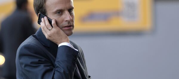 French Economy and Industry minister Emmanuel Macron gives a phone as he visits the 2014 Paris Auto Show on October 3, 2014 in Paris on the second of the two press days. - Sputnik International