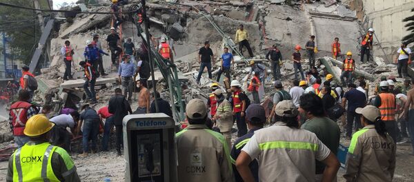 People search for survivors in a collapsed building in the Roma neighborhood of Mexico City, Tuesday, Sept. 19, 2017. A powerful earthquake has jolted Mexico, causing buildings to sway sickeningly in the capital on the anniversary of a 1985 quake that did major damage. People search for survivors in a collapsed building in the Roma neighborhood of Mexico City, Tuesday, Sept. 19, 2017. A powerful earthquake has jolted Mexico, causing buildings to sway sickeningly in the capital on the anniversary of a 1985 quake that did major damage. - Sputnik International