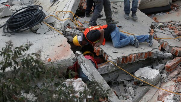 Rescue personnel search for people among the rubble of a collapsed building after an earthquake hit Mexico City, Mexico September 19, 2017 - Sputnik International