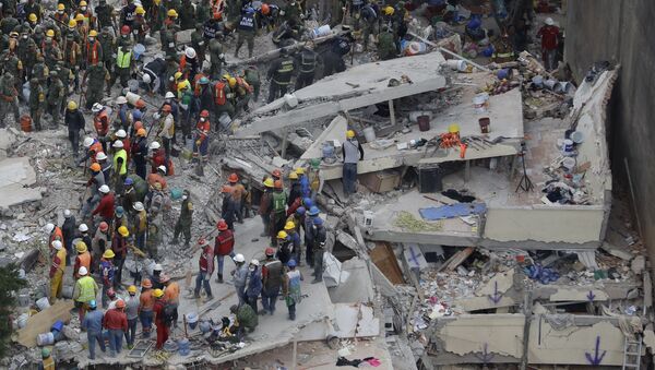 Rescue workers search for people trapped inside a collapsed building in the Del Valle area of Mexico City, Wednesday, Sept. 20, 2017. - Sputnik International