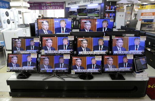 TV screens show a news program with an image of U.S. President Donald Trump and North Korean leader Kim Jong Un - Sputnik International