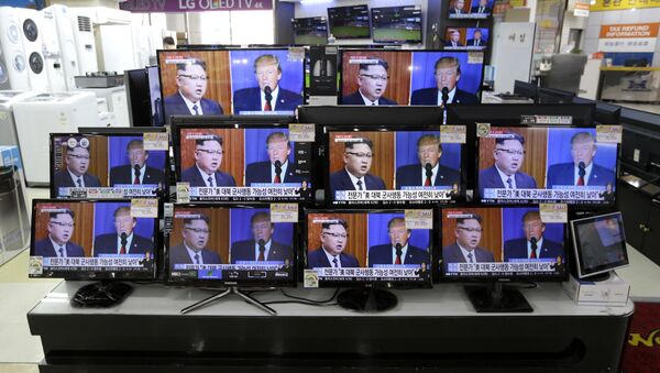 TV screens show a news program with an image of U.S. President Donald Trump and North Korean leader Kim Jong Un - Sputnik International