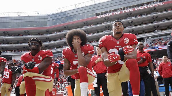 from left, San Francisco 49ers outside linebacker Eli Harold, quarterback Colin Kaepernick and safety Eric Reid kneel during the national anthem before an NFL football game against the Dallas Cowboys in Santa Clara, Calif. Since Kaepernick announced he would not stand for the song in protest of racial discrimination against blacks in the United States, many performers are now rethinking offers to sing the national anthem. - Sputnik International
