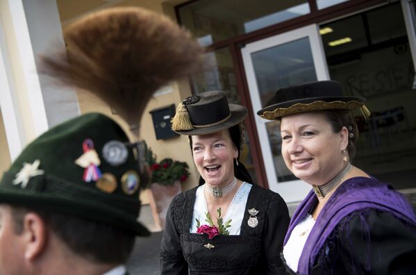 Women and a man in traditional Bavarian costumes stand at a polling station after casting their vote in the German parliament election in Unterwoessen, southern Germany, Sunday, Sept. 24, 2017 - Sputnik International