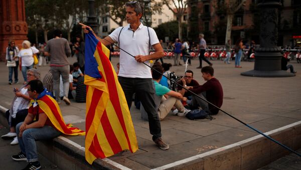 A man places an Estelada (Catalan separatist flag) on a stick during a protest outside the High Court of Justice of Catalonia in Barcelona, Spain, September 21, 2017 - Sputnik International