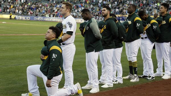Oakland Athletics catcher Bruce Maxwell kneels during the national anthem before the start of a baseball game against the Texas Rangers Saturday, Sept. 23, 2017, in Oakland, Calif. Bruce Maxwell of the Oakland Athletics has become the first major league baseball player to kneel during the national anthem. - Sputnik International