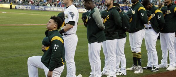 Oakland Athletics catcher Bruce Maxwell kneels during the national anthem before the start of a baseball game against the Texas Rangers Saturday, Sept. 23, 2017, in Oakland, Calif. Bruce Maxwell of the Oakland Athletics has become the first major league baseball player to kneel during the national anthem. Oakland Athletics catcher Bruce Maxwell kneels during the national anthem before the start of a baseball game against the Texas Rangers Saturday, Sept. 23, 2017, in Oakland, Calif. Bruce Maxwell of the Oakland Athletics has become the first major league baseball player to kneel during the national anthem. - Sputnik International