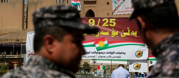 Kurdish policemen look on towards banners supporting the referendum for independence of Kurdistan in Erbil, Iraq September 24, 2017 - Sputnik International