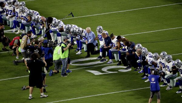 The Dallas Cowboys, led by owner Jerry Jones, center, take a knee prior to the national anthem prior to an NFL football game against the Arizona Cardinals, Monday, Sept. 25, 2017, in Glendale, Ariz. - Sputnik International