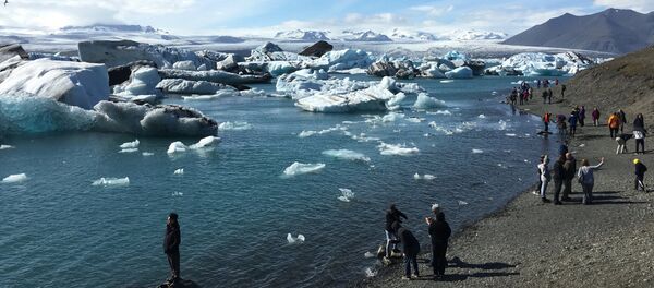 Tourists at the Jokulsarlon, a glacier lagoon in southern Iceland where ice bergs breaking off from the Breidamerkurjokull glacier have formed the country’s deepest lake in the last 80 years, on 4 July 2017 - Sputnik International