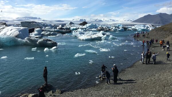 Tourists at the Jokulsarlon, a glacier lagoon in southern Iceland where ice bergs breaking off from the Breidamerkurjokull glacier have formed the country’s deepest lake in the last 80 years, on 4 July 2017 - Sputnik International