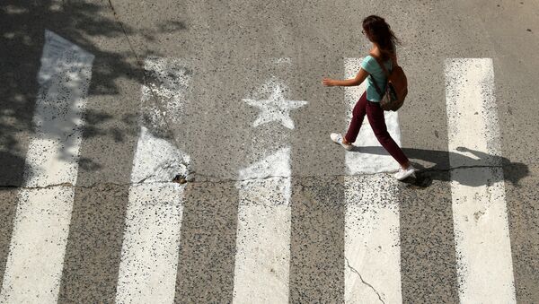 A woman walks past a crosswalk, painted in the form of an Estelada (Catalan pro-independence flag) in Arenys de Munt, north of Barcelona, Spain, September 26, 2017 - Sputnik International