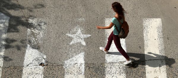 A woman walks past a crosswalk, painted in the form of an Estelada (Catalan pro-independence flag) in Arenys de Munt, north of Barcelona, Spain, September 26, 2017 - Sputnik International