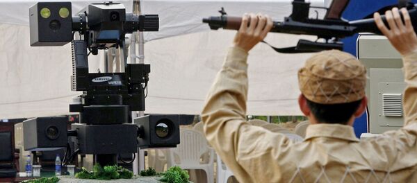 A sentry robot freezes a hypothetical intruder by pointing its machine gun during its test. (File) - Sputnik International