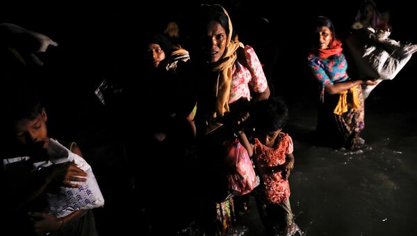 Women and children wade through the water as hundreds of Rohingya refugees arrive under the cover of darkness by wooden boats from Myanmar to the shore of Shah Porir Dwip, in Teknaf, near Cox's Bazar in Bangladesh, September 27, 2017 - Sputnik International