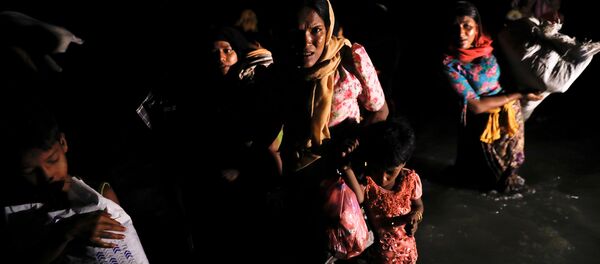Women and children wade through the water as hundreds of Rohingya refugees arrive under the cover of darkness by wooden boats from Myanmar to the shore of Shah Porir Dwip, in Teknaf, near Cox's Bazar in Bangladesh, September 27, 2017 Women and children wade through the water as hundreds of Rohingya refugees arrive under the cover of darkness by wooden boats from Myanmar to the shore of Shah Porir Dwip, in Teknaf, near Cox's Bazar in Bangladesh, September 27, 2017 - Sputnik International