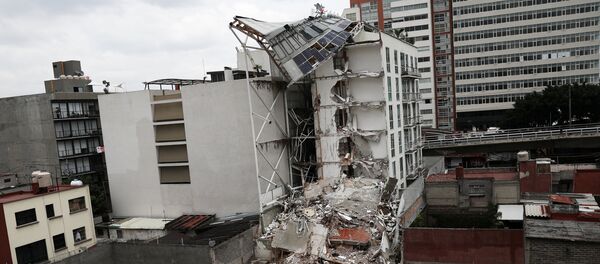 A photojournalist (R) takes a picture of a collapsed building, after an earthquake in Mexico City, Mexico September 28, 2017 A photojournalist (R) takes a picture of a collapsed building, after an earthquake in Mexico City, Mexico September 28, 2017 - Sputnik International
