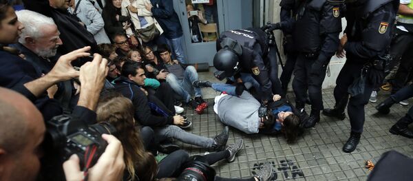 Spanish police officers immobilize some people outside a polling station in Barcelona, on October 1, 2017, on the day of a referendum on independence for Catalonia banned by Madrid - Sputnik International