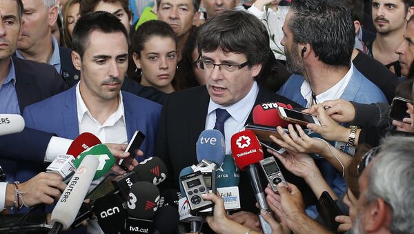 Catalan President Carles Puigdemont, centre, speaks to the media at a sports center, assigned to be a polling station by the Catalan government and where Puigdemont was originally expected to vote, in Sant Julia de Ramis, near Girona, Spain, Sunday, Oct. 1, 2017. Scuffles earlier erupted as voters protested as dozens of anti-rioting police broke into a polling station. - Sputnik International