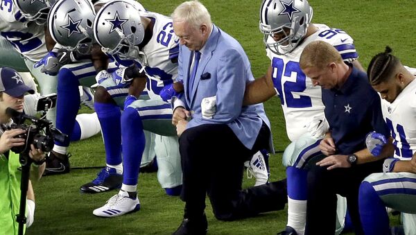In this Monday, Sept. 25, 2017, file photo, the Dallas Cowboys, led by owner Jerry Jones, center, take a knee prior to the national anthem before an NFL football game against the Arizona Cardinals in Glendale, Ariz. What began more than a year ago with a lone NFL quarterback protesting police brutality against minorities by kneeling silently during the national anthem before games has grown into a roar with hundreds of players sitting, kneeling, locking arms or remaining in locker rooms, their reasons for demonstrating as varied as their methods. - Sputnik International
