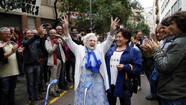 An elderly lady is applauded as she celebrates after voting at a school assigned to be a polling station by the Catalan government at the Gracia neighborhood in Barcelona, Spain, Sunday, 1 Oct. 2017. The Spanish government and its security forces are trying to prevent voting in the independence referendum, which is backed by Catalan regional authorities. Spanish officials had said force wouldn't be used, but that voting wouldn't be allowed. - Sputnik International