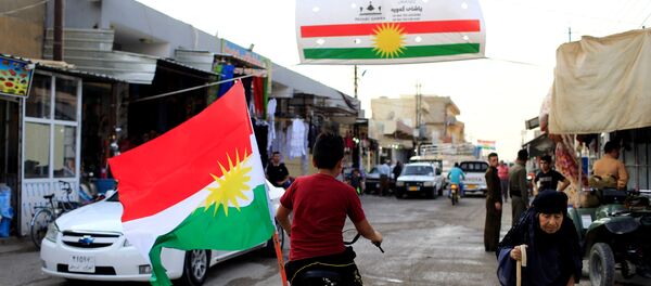 A boy rides a bicycle with the flag of Kurdistan in Tuz Khurmato, Iraq September 24, 2017 - Sputnik International