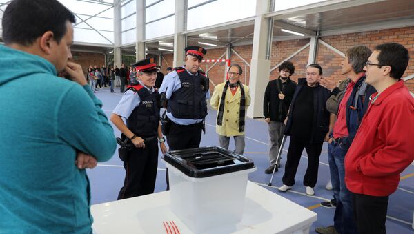 A couple of Mossos D'Esquadra (Catalan police) enter a polling station in Figueras, on October 1, 2017, on the day of a referendum on independence for Catalonia banned by Madrid - Sputnik International