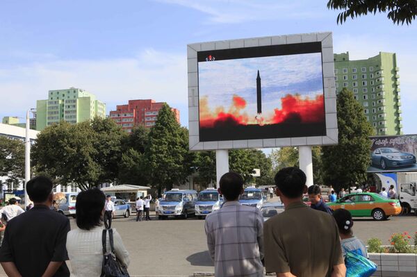 People watch a launching of a Hwasong-12 strategic ballistic rocket aired on a public TV screen at the Pyongyang Train Station in Pyongyang, North Korea, Saturday, Sept. 16, 2017 - Sputnik International