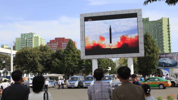 People watch a launching of a Hwasong-12 strategic ballistic rocket aired on a public TV screen at the Pyongyang Train Station in Pyongyang, North Korea, Saturday, Sept. 16, 2017 - Sputnik International