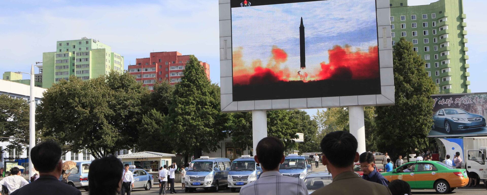 People watch a launching of a Hwasong-12 strategic ballistic rocket aired on a public TV screen at the Pyongyang Train Station in Pyongyang, North Korea, Saturday, Sept. 16, 2017 - Sputnik International, 1920, 13.07.2023