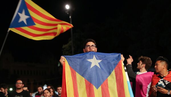A man holds an Estelada (Catalan separatist flag) as people gather at Plaza Catalunya after voting ended for the banned independence referendum, in Barcelona, Spain - Sputnik International