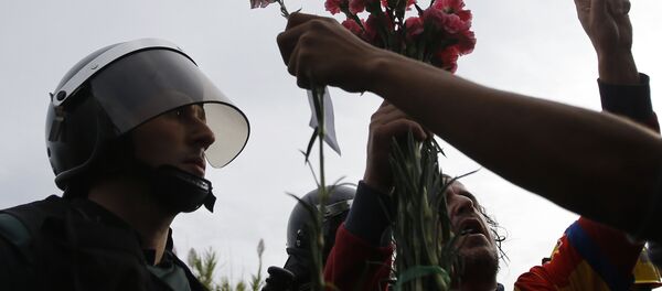 People try to offer flowers to a civil guard at the entrance of a sports center, assigned to be a referendum polling station by the Catalan government in Sant Julia de Ramis, near Girona, Spain, Sunday, Oct. 1, 2017. Scuffles have erupted as voters protested while dozens of anti-rioting police broke into a polling station where the regional leader was expected to show up for voting on Sunday. People try to offer flowers to a civil guard at the entrance of a sports center, assigned to be a referendum polling station by the Catalan government in Sant Julia de Ramis, near Girona, Spain, Sunday, Oct. 1, 2017. Scuffles have erupted as voters protested while dozens of anti-rioting police broke into a polling station where the regional leader was expected to show up for voting on Sunday. - Sputnik International