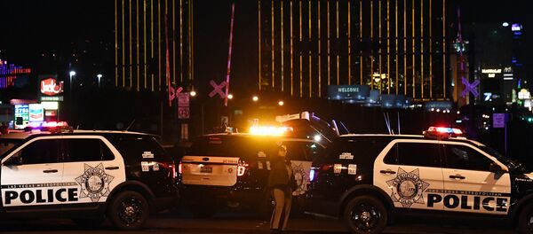 Police form a perimeter around the road leading to the Mandalay Hotel (background) after a gunman killed at least 50 people and wounded more than 200 others when he opened fire on a country music concert in Las Vegas, Nevada Police form a perimeter around the road leading to the Mandalay Hotel (background) after a gunman killed at least 50 people and wounded more than 200 others when he opened fire on a country music concert in Las Vegas, Nevada - Sputnik International