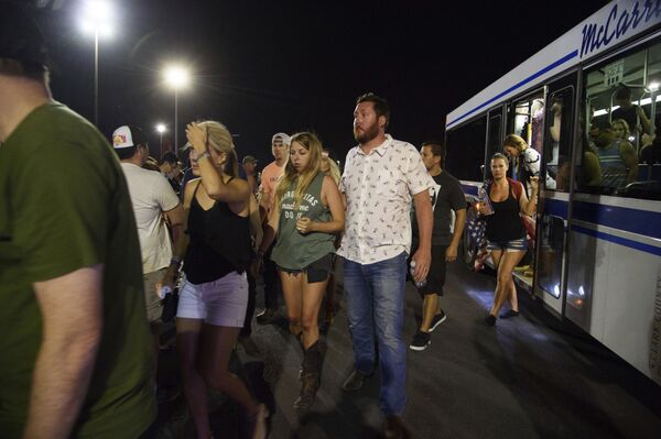 People arrive to Thomas & Mack Center via bus after hiding inside the Sands Corporation plane hangar after a mass shooting in which dozens were killed at the Route 91 Harvest country festival on early Monday, Oct. 2, 2017, in Las Vegas People arrive to Thomas & Mack Center via bus after hiding inside the Sands Corporation plane hangar after a mass shooting in which dozens were killed at the Route 91 Harvest country festival on early Monday, Oct. 2, 2017, in Las Vegas - Sputnik International