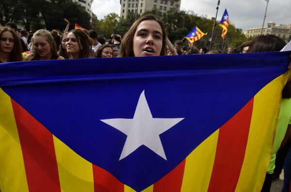 A student holds a Catalan pro-independence 'Estelada' flag during a protest in Barcelona on October 2, 2017 a day after hundreds were injured in a police crackdown during Catalonia's banned independence referendum A student holds a Catalan pro-independence 'Estelada' flag during a protest in Barcelona on October 2, 2017 a day after hundreds were injured in a police crackdown during Catalonia's banned independence referendum - Sputnik International