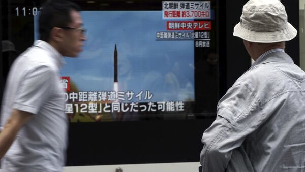 A man, right, watches a public TV screen broadcasting news of North Korea's launch of missile, in Tokyo - Sputnik International