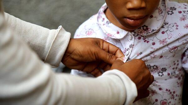 Fabiana Désilus arranges the clothes of Izafana, girl who was born after the rape of a soldier of Jordan - Sputnik International