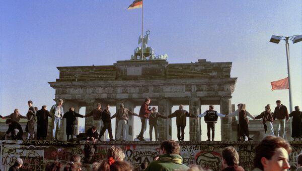 Berliners sing and dance on top of the Berlin Wall to celebrate the opening of East-West German borders, Friday afternoon, Nov. 10, 1989.  - Sputnik International